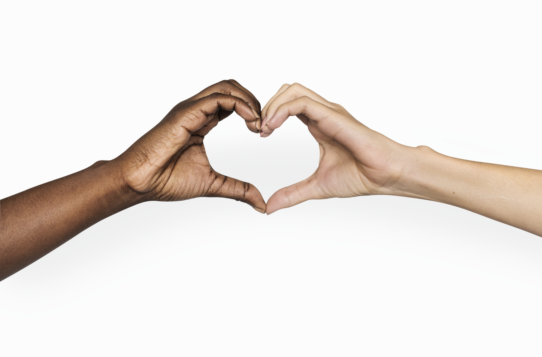 Two hands, one dark and one light, forming a heart shape together