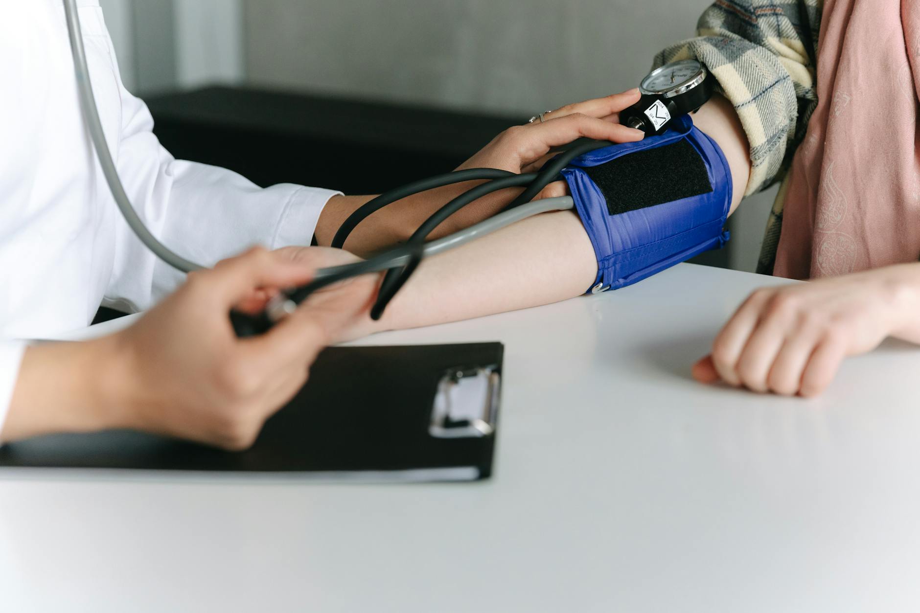 Healthcare professional measuring a patient’s blood pressure with an arm cuff