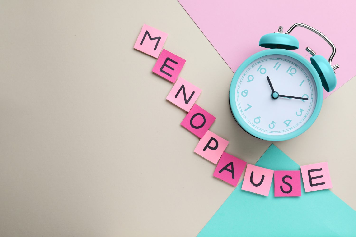 Menopause letter blocks beside an alarm clock representing midlife changes after 40