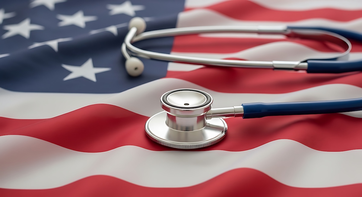A stethoscope lying across the American flag, illustrating the state and history of the U.S. healthcare system